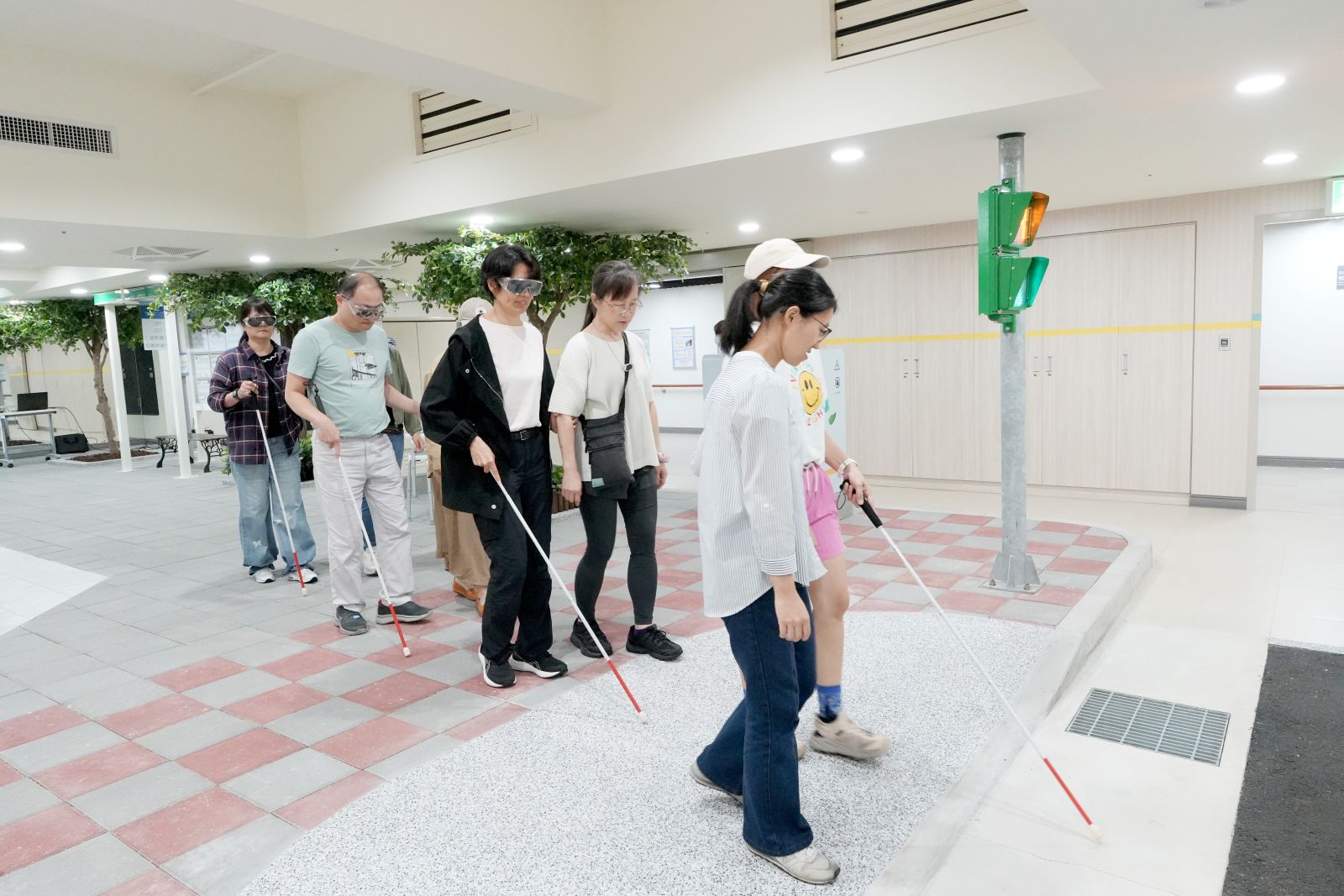 兩人一組練習以人導法帶領視障者過馬路。