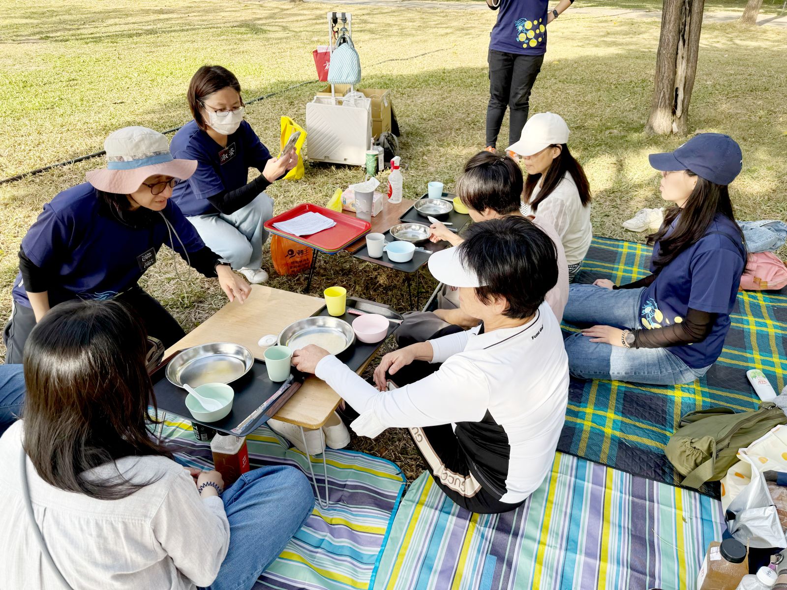 在天氣宜人的公園野餐，邊和其他視障學員交流。
