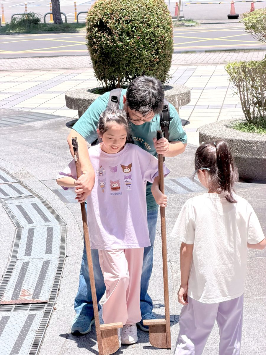 家長陪著孩子練習踩高蹺。