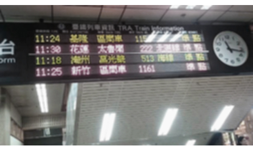 戴上色盲眼鏡後看台北火車站的電子車班佈告(單色)，電子資料變得較為清晰可辨(實景模擬圖)
