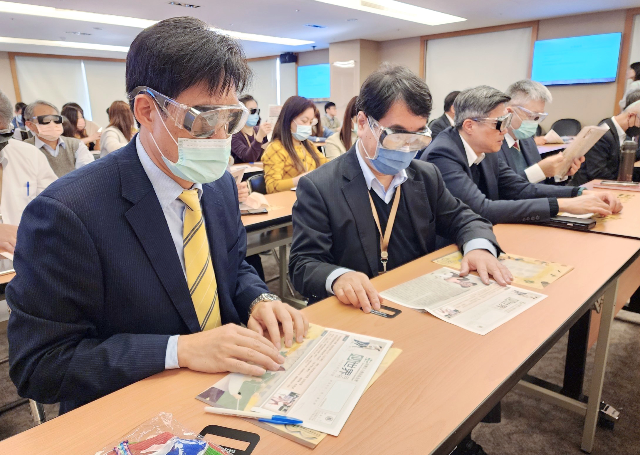 兆豐證券同仁配戴視覺模擬眼鏡進行低視能體驗。